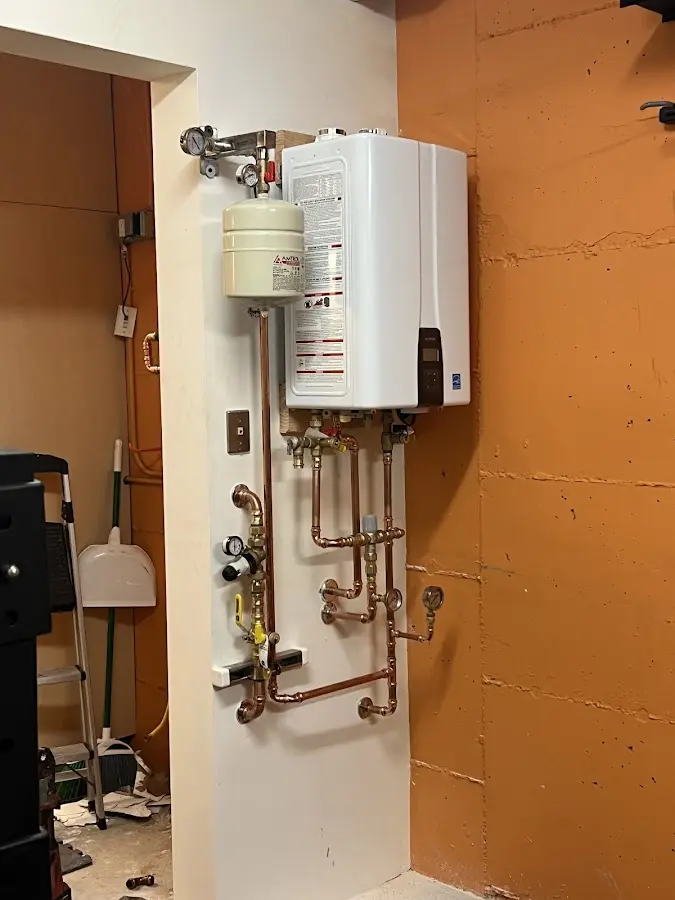 Plumbing technician inspecting water heater connections in Riga